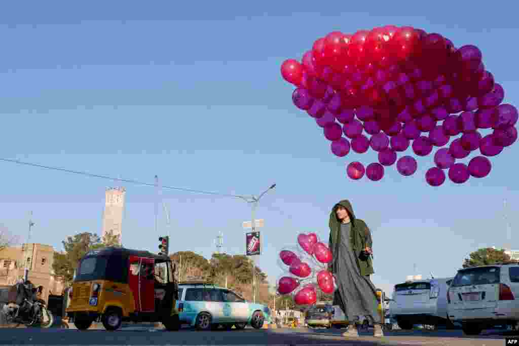 An Afghan boy sells balloons along a road in Herat Province.&nbsp;