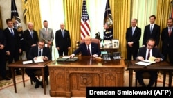 U.S. President Donald Trump (center) speaks before Kosovar Prime Minister Avdullah Hoti (right) and Serbian President Aleksandar Vucic sign an agreement on opening economic relations, in the Oval Office at the White House on September 4.