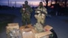 Ukrainian forces pose next to boxes of equipment donated to them by pro-Kyiv activists from across the country who have been collecting money to buy much-needed supplies for the country's cash-strapped army.