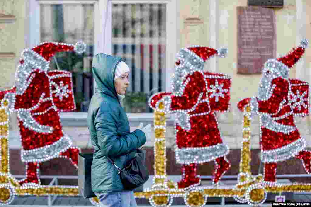 A woman passes Christmas decorations in the center of the Moldovan capital, Chisinau.&nbsp;