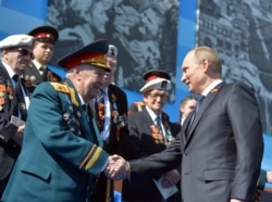 Vladimir Putin shakes hands with a World War II veteran during Victory Day celebrations in 2015,