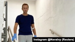 Russian opposition politician Alexei Navalny walks down stairs at Charite hospital in Berlin in an undated image obtained from social media.