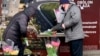 A customer buys a bouquet of tulips near a subway station in Kyiv. Somewhere along the line, calls for women’s rights and equality were eclipsed by gifts of greeting cards, bouquets, and sweets.