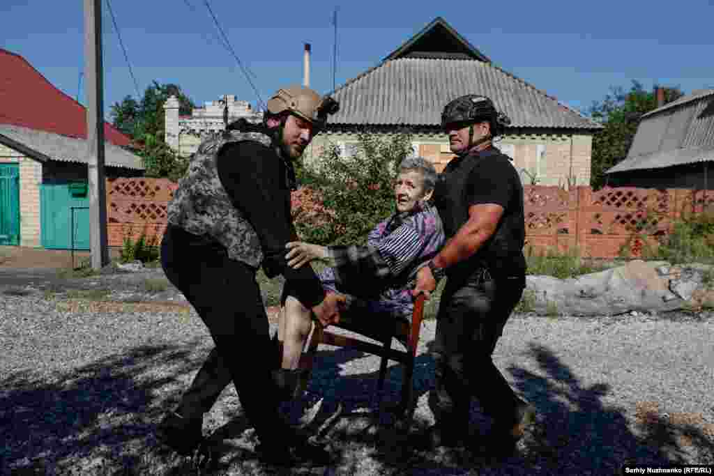 A woman is evacuated from Novohrodivka, Donetsk region, in August 2024. Russian troops occupied the town 20 days after this photo was taken. The man on the right is Owen, a volunteer from New Zealand. A former combat medic, he came to Ukraine to help save people.