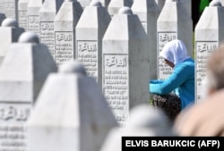 A Bosnian Muslim woman, a survivor of the 1995 Srebrenica massacre, prays near the graves of her relatives at the memorial cemetery in Potocari, near Srebrenica, on July 11.