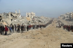 Displaced Palestinians make their way past the rubble as they attempt to return to their homes in the northern Gaza Strip on January 19.