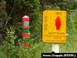 A Russian border post (left) behind an Estonian border marker that says “STOP” in Estonian, English, and Russian. Estonian police warn people to stay more than 15 meters away from these Russian border markers.