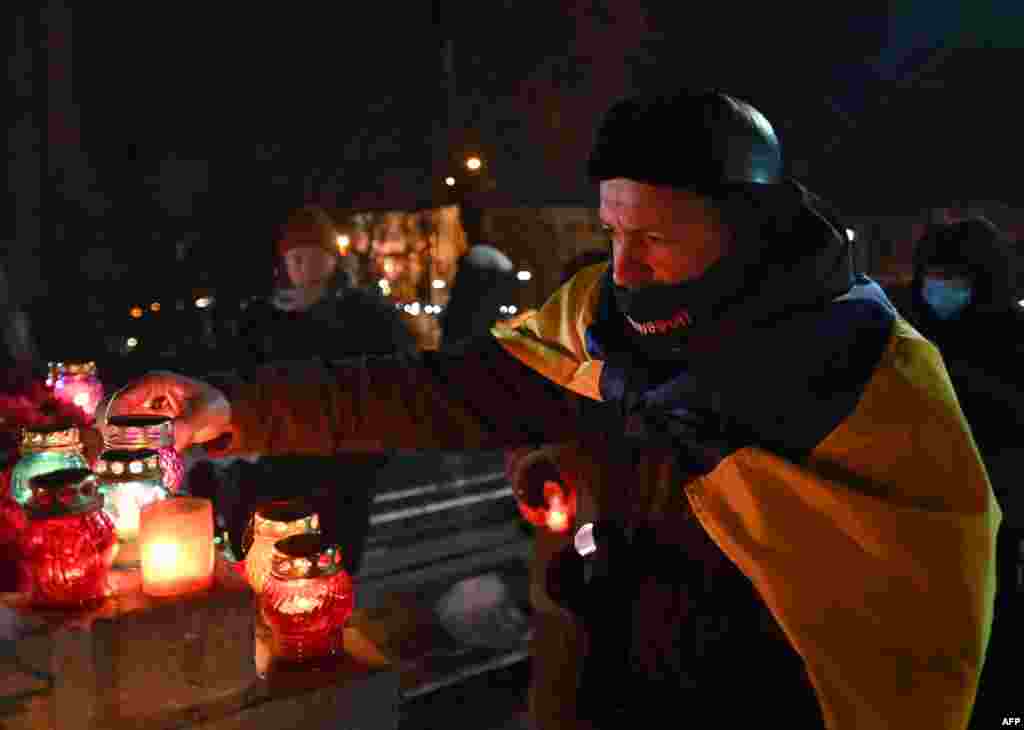 This man lights a candle at the memorial...