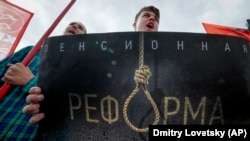 People hold up a poster reading "Pension reform" during a Communist Party rally against the retirement-age hikes in St. Petersburg on September 2.