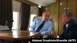 Rosneft oil giant CEO Igor Sechin talks with Russian President Vladimir Putin aboard a private jet in 2018.