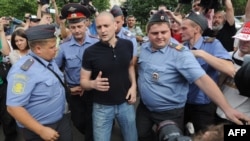 Police officers detain radical Russian opposition leader Sergei Udaltsov (center) during an opposition rally in August 2012.