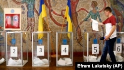 A man casts his ballot paper at a polling station during a parliamentary election in Kyiv in July 2019. 