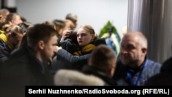 Ukraine International Airlines employees embrace during a farewell ceremony for the victims of the Flight PS752 disaster on January 19 in Kyiv. The plane was shot down after takeoff from Tehran on January 8 in what Iran's military said was a mistake. Nine crew members were killed along with 167 other people on board. (Serhii Nuzhnenko, RFE/RL)