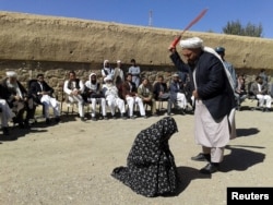 A woman found guilty of adultery receives 100 lashes in front of a crowd in Ghor Province in 2015.