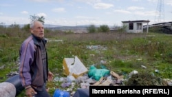 Srdjan Milic stands in his backyard in Palaj, a settlement near Obiliq, a town in central Kosovo.