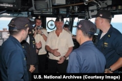 A Russian captain (center) speaks with U.S. Navy officers during his visit to the bridge of a U.S. guided missile cruiser.