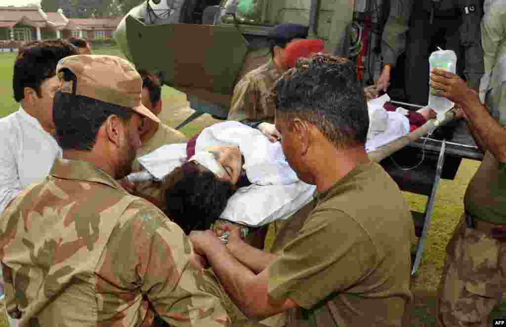 On October 9, 2012, Taliban militants shot her as she boarded a school bus, injuring her and two classmates. In this photo, soldiers shift the injured Yousafzai from a helicopter at an army hospital in Rawalpindi following the attack.