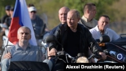 Russian President Vladimir Putin (center) with the Kremlin-linked bikers club Night Wolves, which has been targeted in the latest round of EU sanctions against Russia. (file photo)