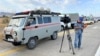 Journalists close to the site of where an explosion occurred in Kazakhstan's Baizak district on August 27.