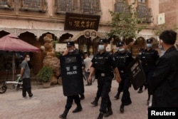 Police officers patrol in the old city in Kashgar, in China's Xinjiang Uyghur Autonomous Region.