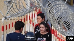 Uyghur women walk through a security checkpoint to enter a bazaar in Hotan, in China's Xinjiang Uyghur Autonomous Region.