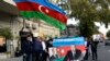 People wave the national flag and hold portraits of Azerbaijani President Ilham Aliyev and his father and predecessor Heydar as they celebrate in the streets of Baku on November 10.