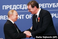 Russian President Vladimir Putin (left) shakes hands with Serbian President Aleksandar Vucic after being awarded the Order of Aleksander Nevsky in Belgrade in January 2019.