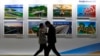 People walk by a display board showcasing China's construction projects at the media center of the Belt and Road Initiative in Beijing. (file photo)