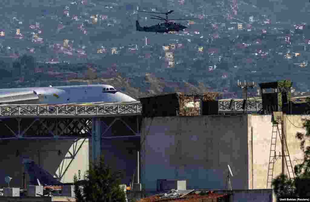 A Russian attack helicopter patrols the Hmeimim air base. Bektas says it is unclear whether the influx of Russian troops to the Hmeimim base from positions elsewhere across Syria will remain there, or whether they are awaiting an airlift out of Syria.&nbsp;