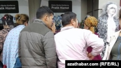 Turkmen migrants stand in line in front of an ATM in Istanbul, Turkey. 