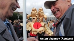 Two people in a costume depicting the Russian state symbol of a double-headed eagle take part in a rally in St. Petersburg calling for opposition candidates to be registered for elections to Moscow's city council. 