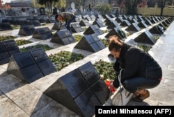 People light candles at a cemetery in Timisoara for victims of the Romanian revolution of December 1989.