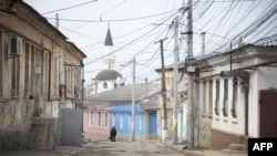 A woman walks along a street of the old town of Simferopol.