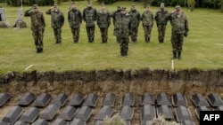 German soldiers salute during the reburial ceremony of the remains of German WWII soldiers at the German cemetery in Sologubovka outside St. Petersburg in September 2017. 