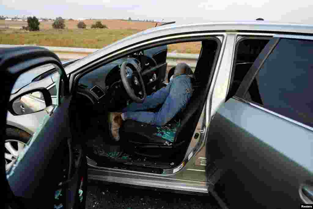 A man and woman lie dead in a car&nbsp;in the Sderot area of southern Israel on October 7, 2023, following the deadly attack by Hamas gunmen.