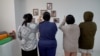 Thai women at a property that houses prospective surrogate mothers. On the walls are pictures of babies born to the resident mothers.