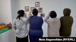 Thai women at a property that houses prospective surrogate mothers. On the walls are pictures of babies born to the resident mothers.