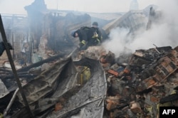 Ukrainian emergency workers extinguishing a fire in a home after a drone strike in Kharkiv on December 25.