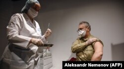 A man prepares to receive an injection of Russia's Sputnik-V vaccine against the coronavirus in an inoculation station at the GUM department store in Moscow on January 18.