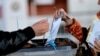 A voter casts her ballot at a voting center in Pristina. (file photo)