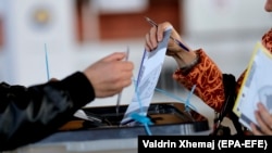 A voter casts her ballot at a voting center in Pristina. (file photo)