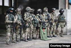 A photo from Sato’s collection showing a group of fellow airsoft enthusiasts in Russian FSB Alpha Group uniforms. There is a replica of an “assault shield” used by the FSB’s special forces (center right).