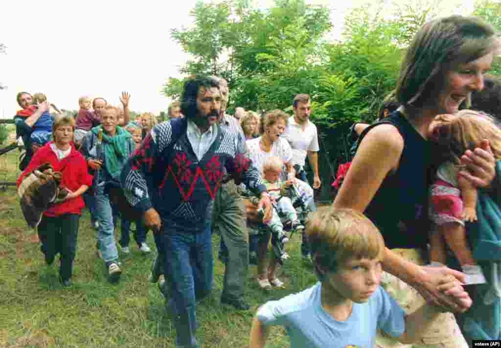 East Germans flee from Hungary into Austria on August 19, 1989, during the &ldquo;Pan-European Picnic.&rdquo; Thousands of East Germans began fleeing Hungary into Austria, including some 600 in a single day during a festival-like protest branded the Pan-European Picnic on the Austria-Hungary border. The exodus, which was soon openly permitted by Hungary, sparked furious protest from East Germany, which claimed its citizens had been &quot;seduced and paid to emigrate...to slander our state.&quot; &nbsp;