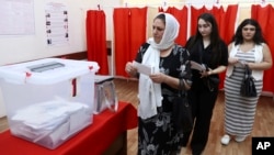 Voters line up to cast their ballots at a polling station in Baku on September 1. 