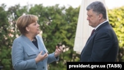 German Chancellor Angela Merkel (left) and Ukrainian President Petro Poroshenko talk during a meeting in Berlin on April 10.