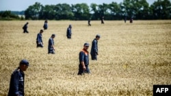 Emergency workers search for bodies at the crash site of Malaysian Airliner MH17, which was downed on July 17, 2014, killing all 298 on board.