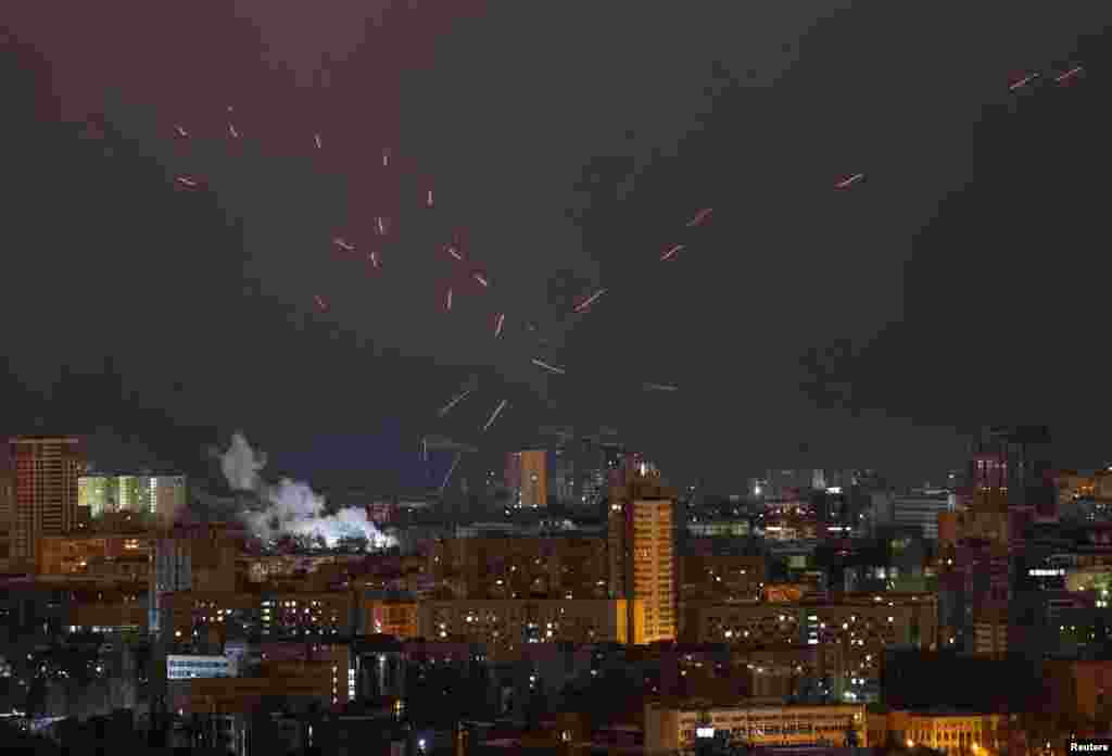 Tracers are seen in the night sky over Kyiv as Ukrainian servicemen fire at a drone during a Russian air attack on the Ukrainian capital. 