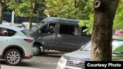 A van with Belarusian security officers pictured outside RFE/RL's offices in Minsk on July 16. 