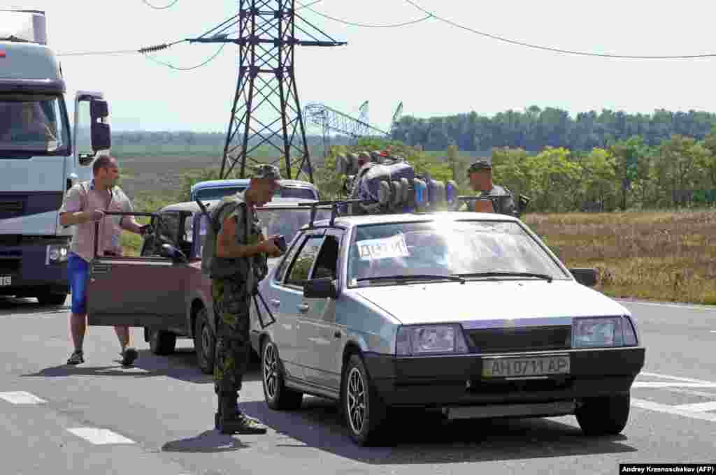 A Ukrainian serviceman checking documents at a checkpoint near Maryinka in August 2014.&nbsp;&nbsp;