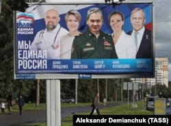 A man walks past a campaign billboard of the United Russia party in St. Petersburg.